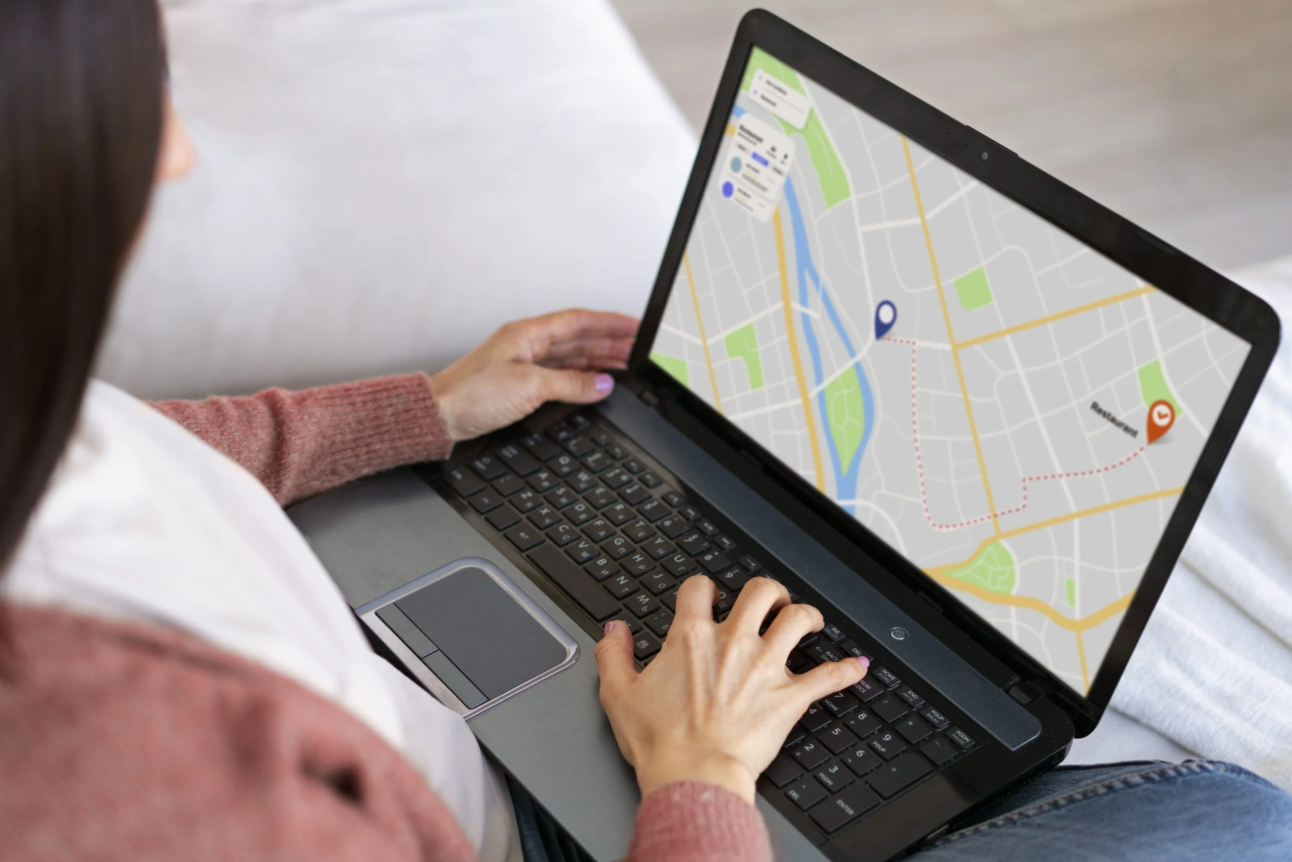 Donna Che Utilizza Un Laptop Con Una Mappa Sullo Schermo Che Mostra Un Percorso Verso Un Ristorante.
